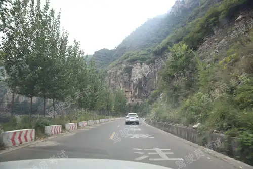 如圖所示，駕駛機(jī)動車在這種落石多發(fā)的山區(qū)道路行駛，以下說法正確的是什么？A、盡量靠道路左側(cè)通行B、停車瞭望，緩慢通過C、盡量避免臨時停車D、勤鳴喇叭，低速通行答案是C